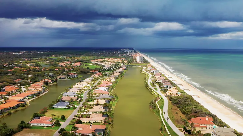 Aerial view of homes and a green between the Intracoastal and the beach