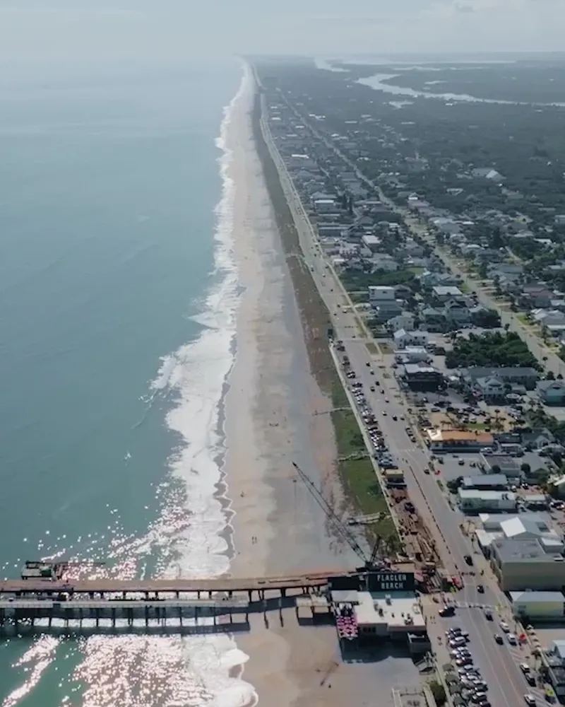 An aerial view of the beach, a pier and the coastline